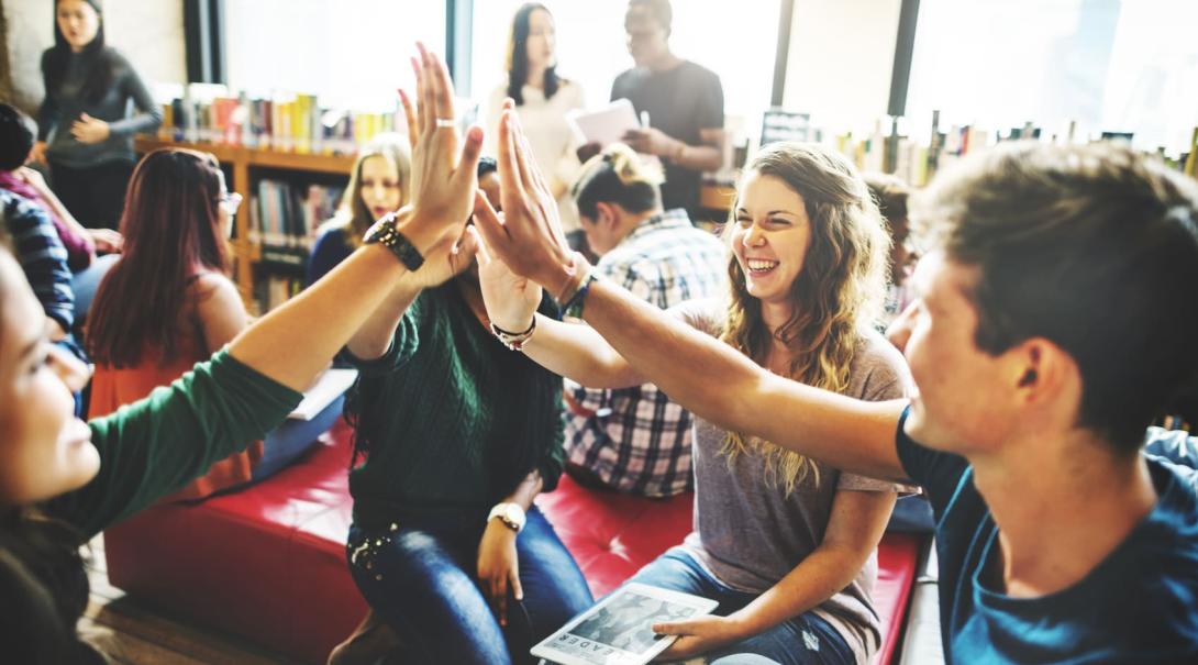 Students in bookstore discussing coursework Students high five each other after they figure out a solution to case study while on their Backpack University